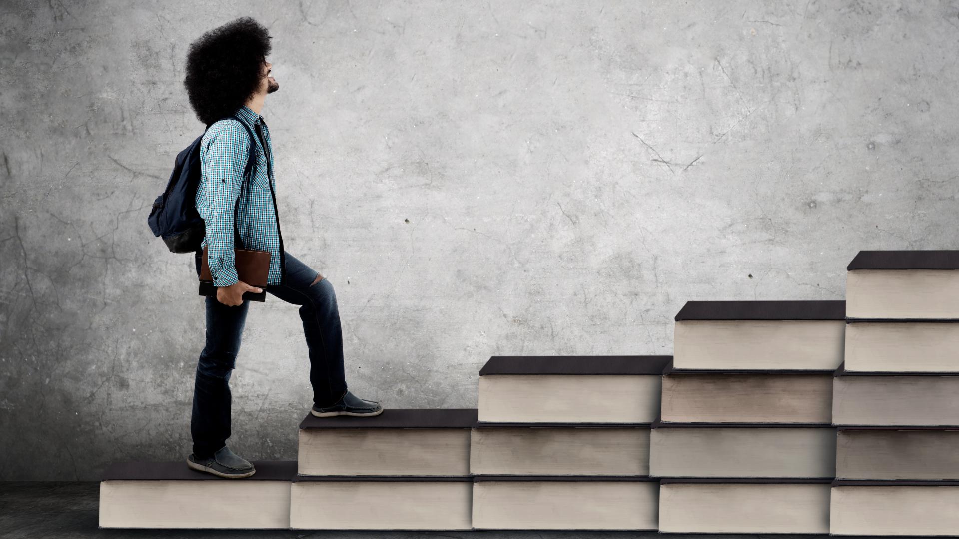 Man op trap van boeken