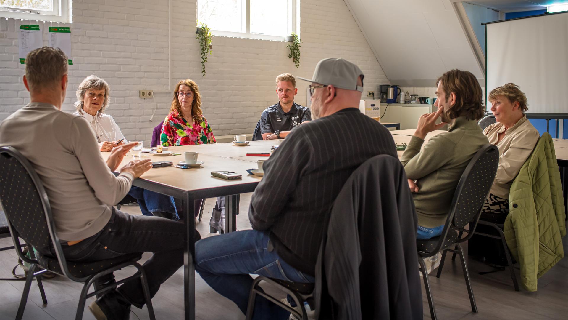 Mensen in overleg om een tafel