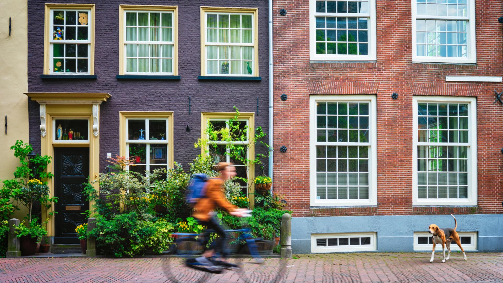 man fietst langs huizen