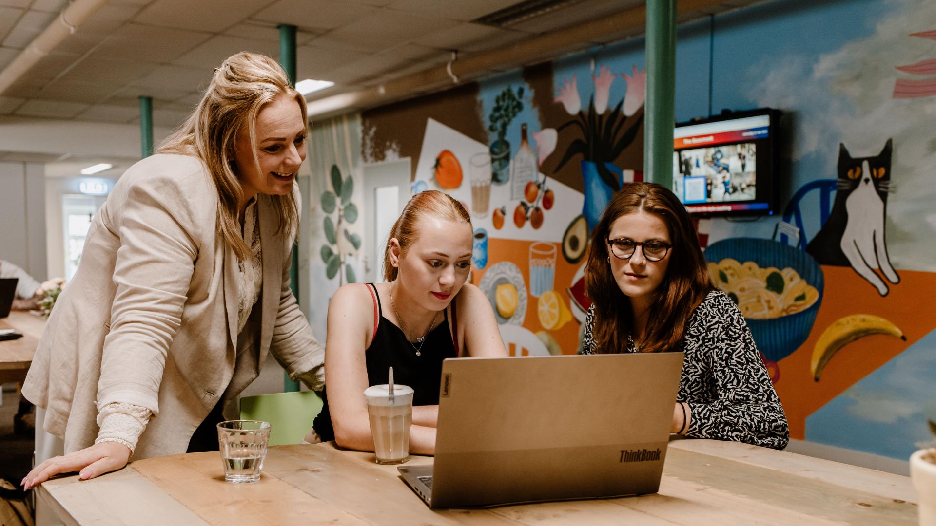 Drie vrouwen achter laptop - Foto: Henrieke Besselink Fotografie