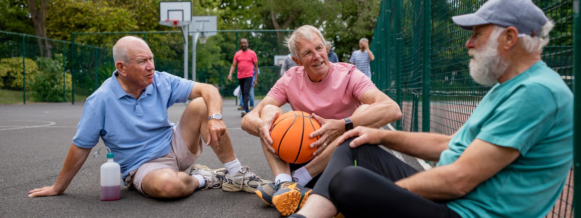 Ouderen zitten op de grond op sportveld