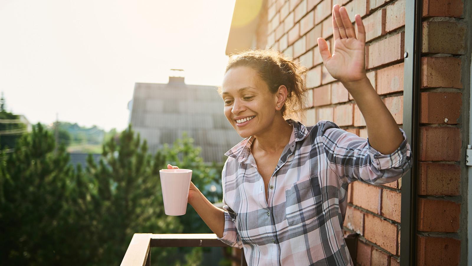 Vrouw zwaaiend op balkon