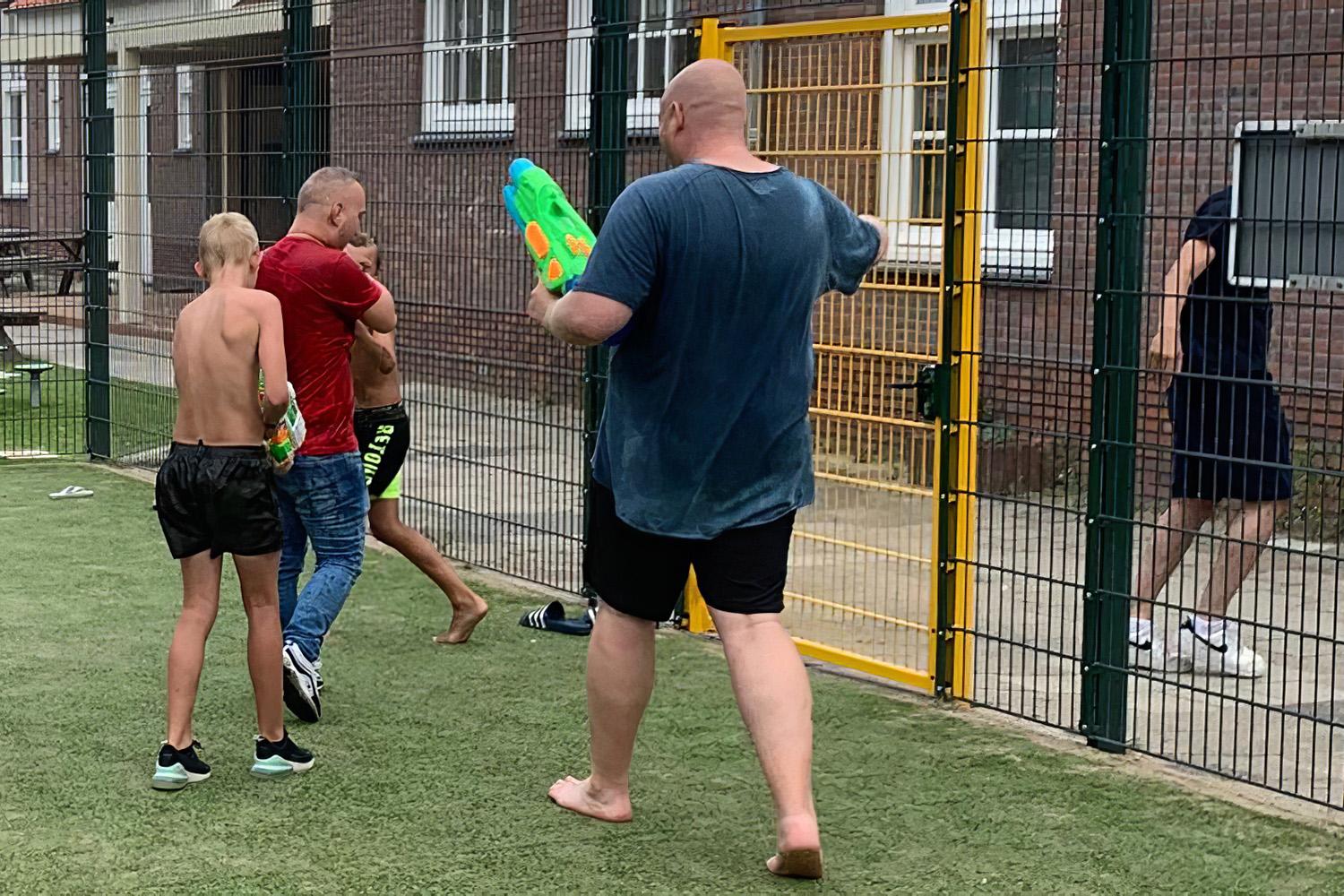 Jongerenwerker Raymon Erberveld met jongeren op het speelveld van het wijkcentrum in Scheveningen.
